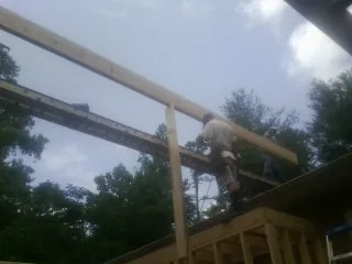 Carpenter setting a ridge beam over a new addition frame — Ice Dam Removal by Roofing Brothers in Fanwood