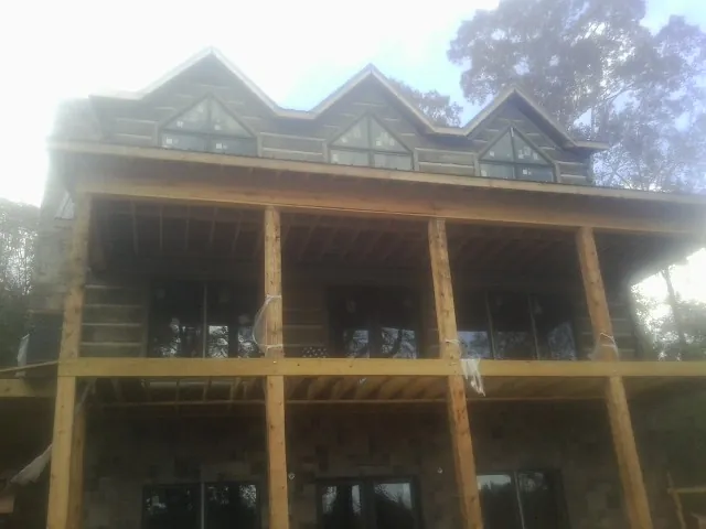 Dormers and porch framing on a large log home under construction — Roof Coating work by our crew in Fanwood
