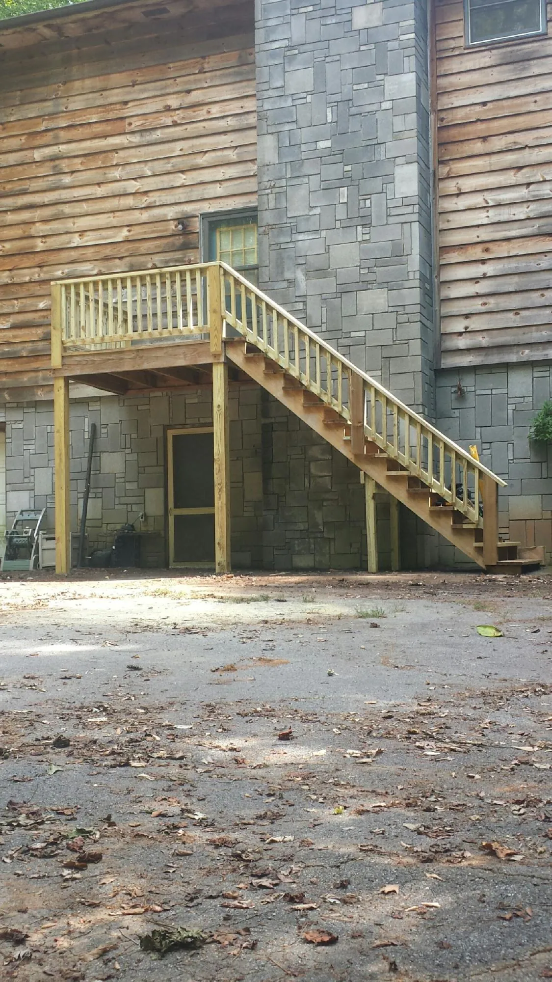 New pressure treated deck and stair landing on a log home in Fanwood