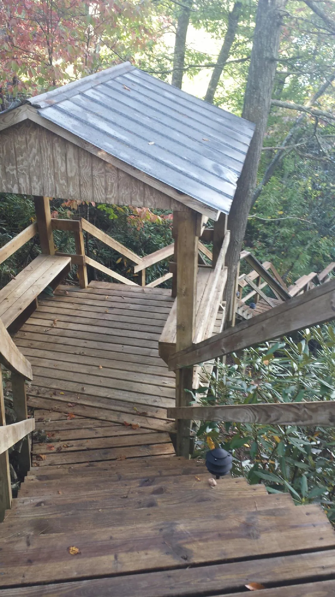 Metal roofed shelter over wooden steps on a wooded walkway — Skylight Repair & Installation work by our crew in Fanwood